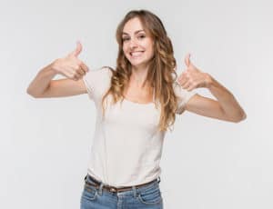 A girl giving a thumbs up because she elevated her mood by boosting Dopamine